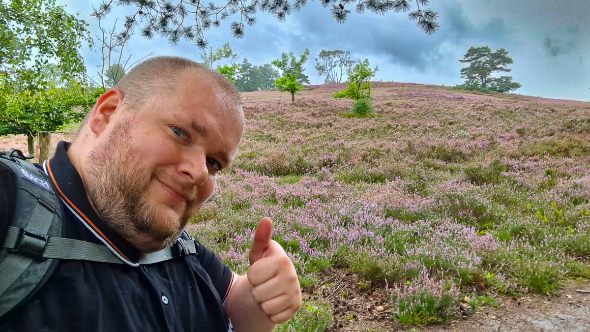 KonBon vor der Heidelandschaft zeigt den Daumen nach oben